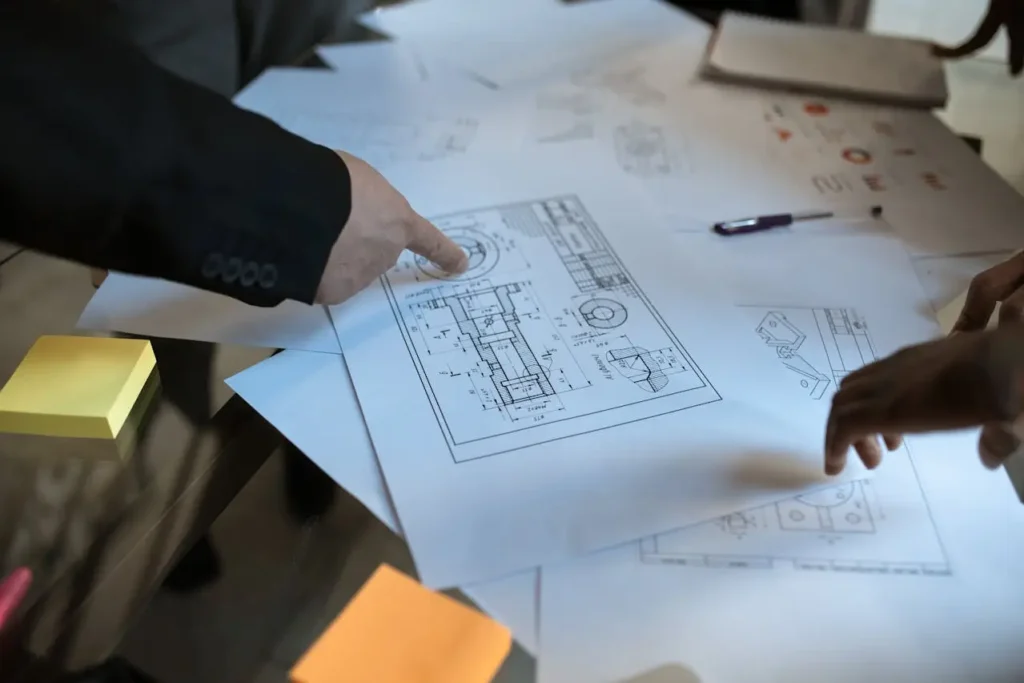 Quantity Surveyors Wellington reviewing construction blueprints on a table.